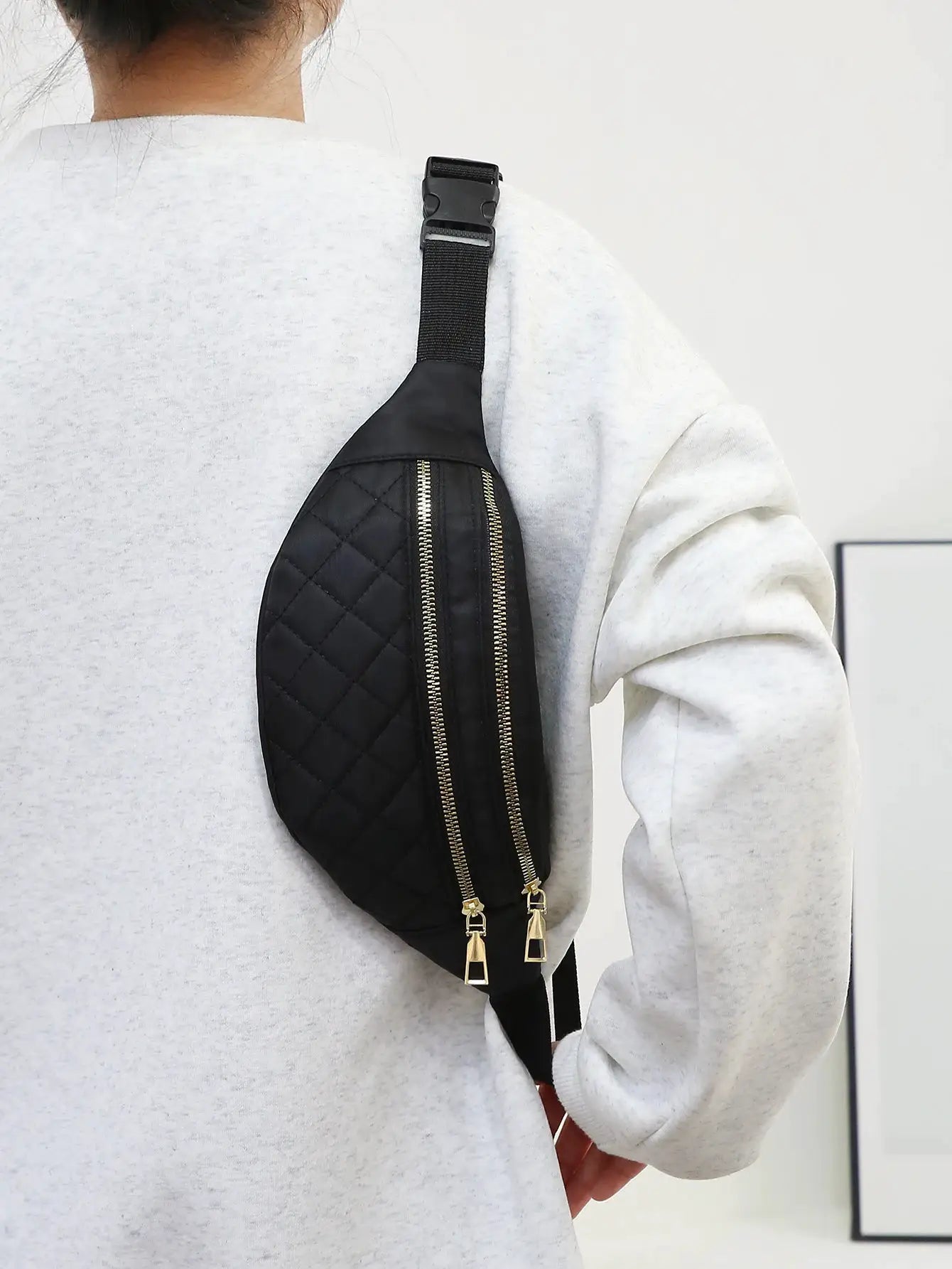 Women waist bag black quilted crossbody fanny pack with dual gold zippers.