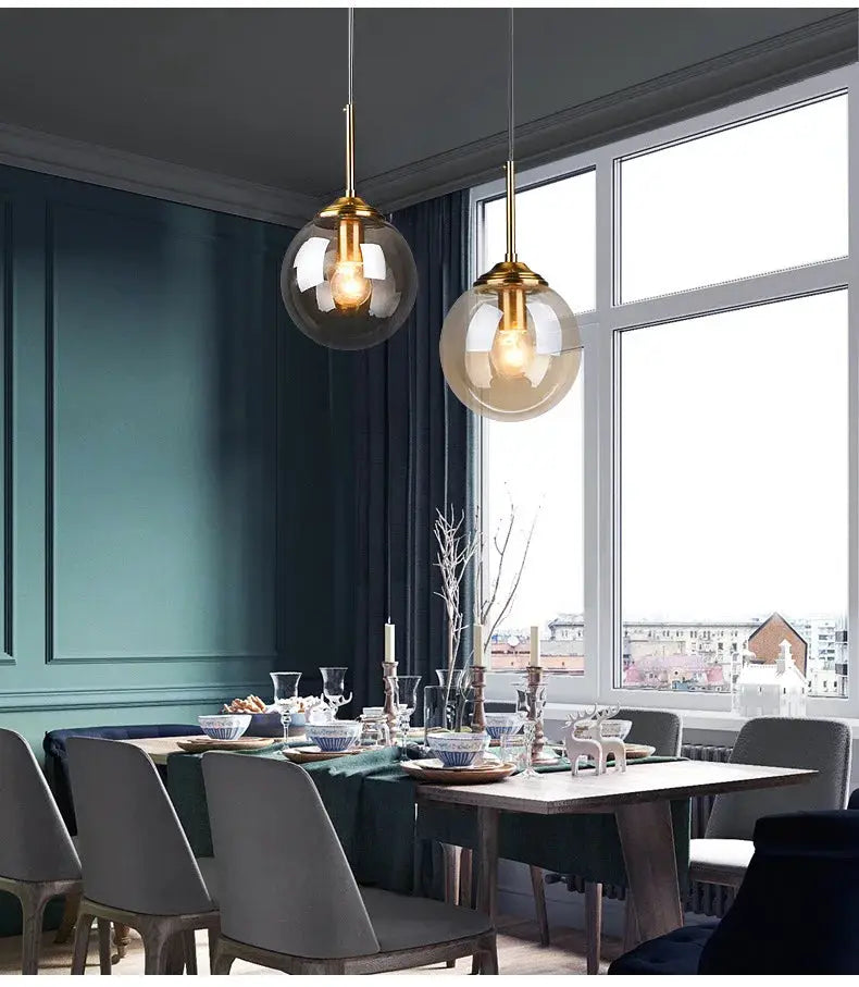 Modern luxury metal chandelier with glass globe pendants and brass accents, LED lighting, pair over dining table