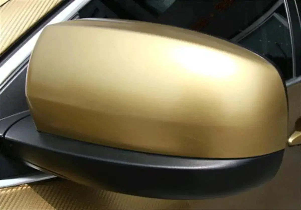 Matte gold vinyl wrap on a car side mirror with air-release channels