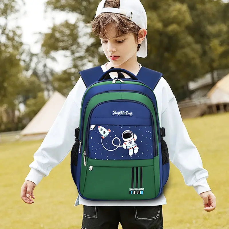Space-themed school backpack for boys, blue and green with astronaut and rocket graphic; brand logo visible.
