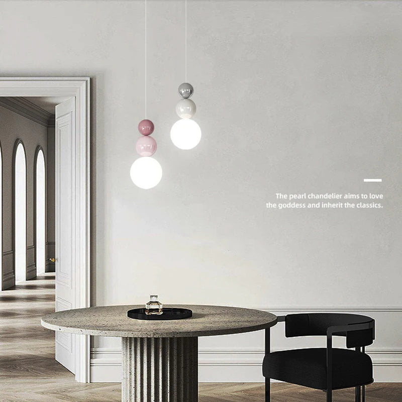 Two Nordic pendant lights with modern LED hanging globes in cream and pastel pink