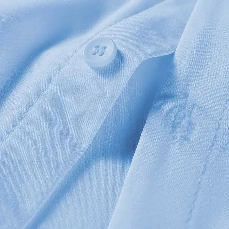 Men's light blue dress shirt fabric close-up with button detail