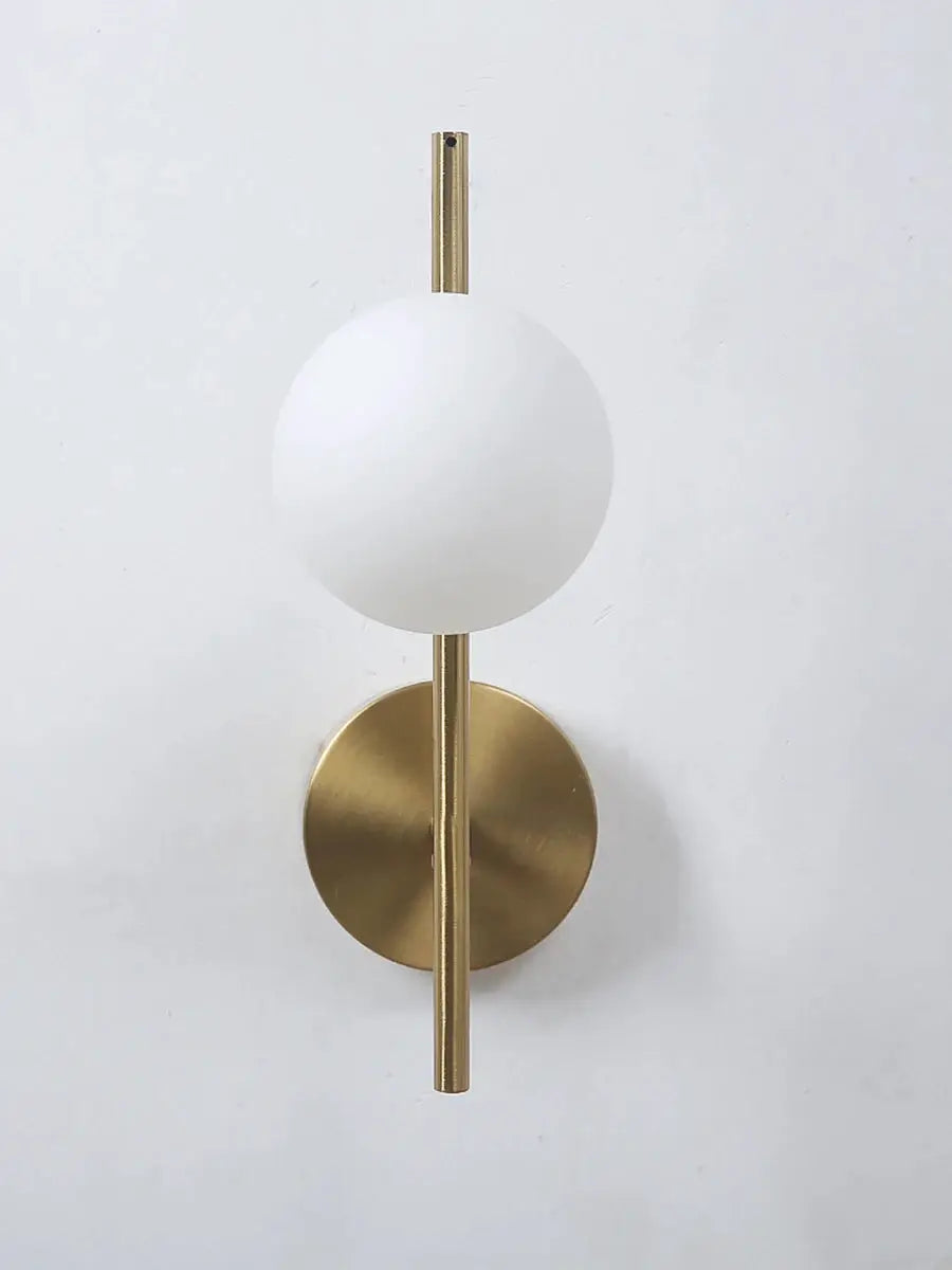 Modern LED wall lamp with milky glass globe and gold brass stem on round wall mount