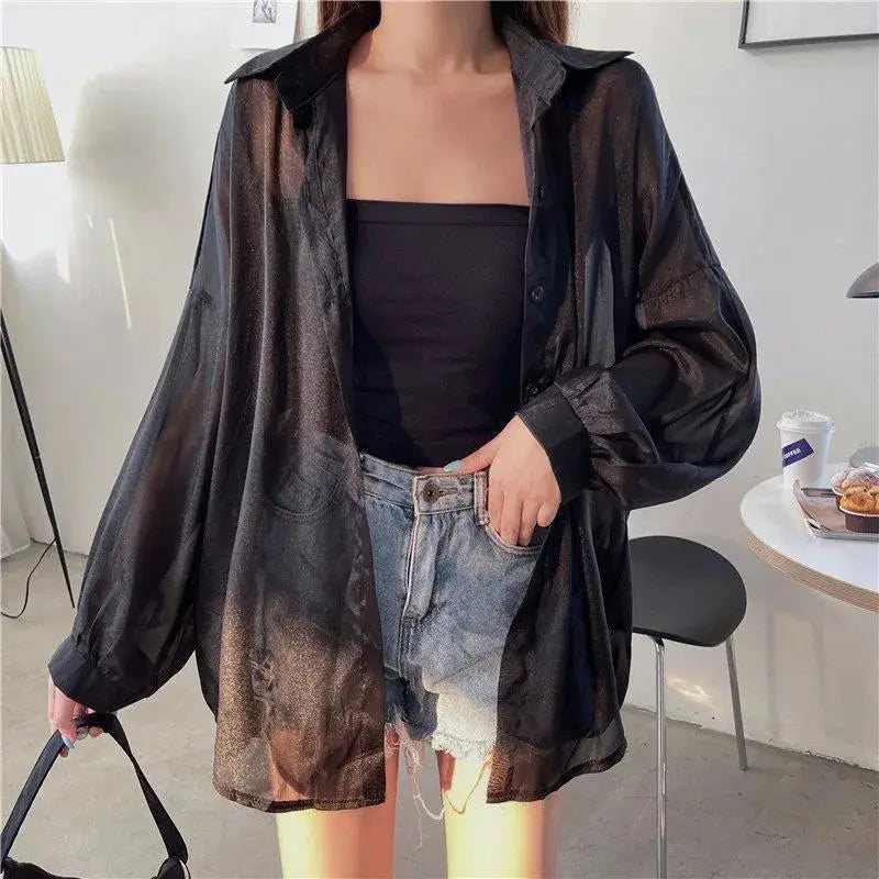 Women’s sheer black chiffon shirt worn open over a black strapless top with loose long sleeves