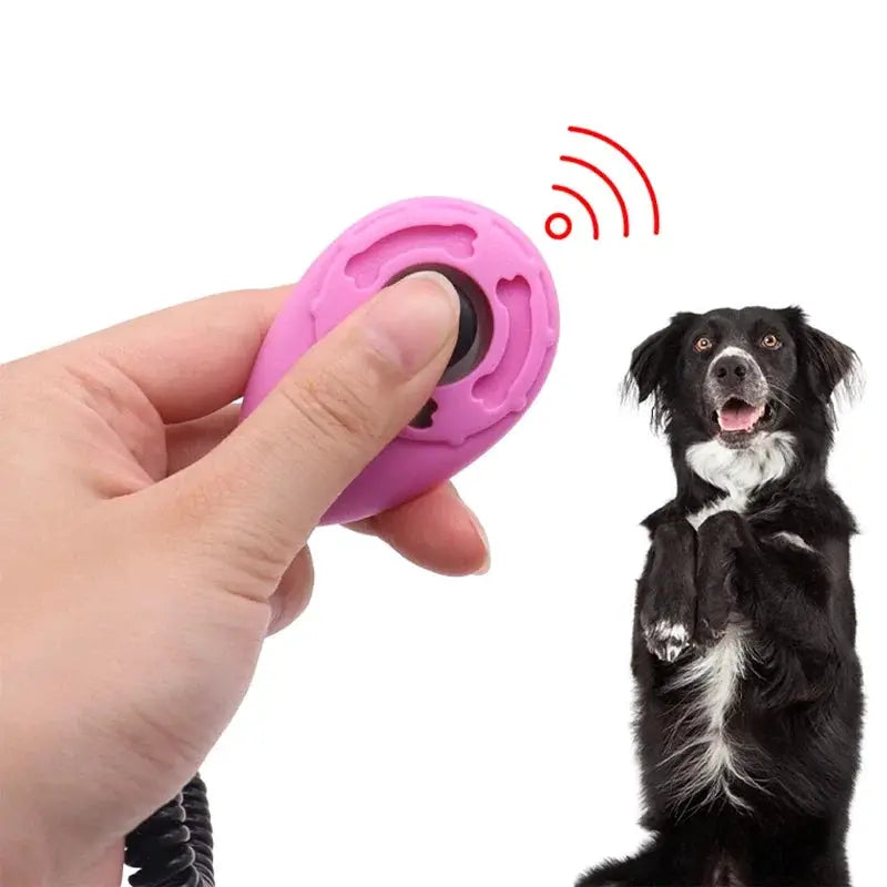 Pink Simples Market adjustable dog training clicker with wrist strap, handheld; dog standing nearby