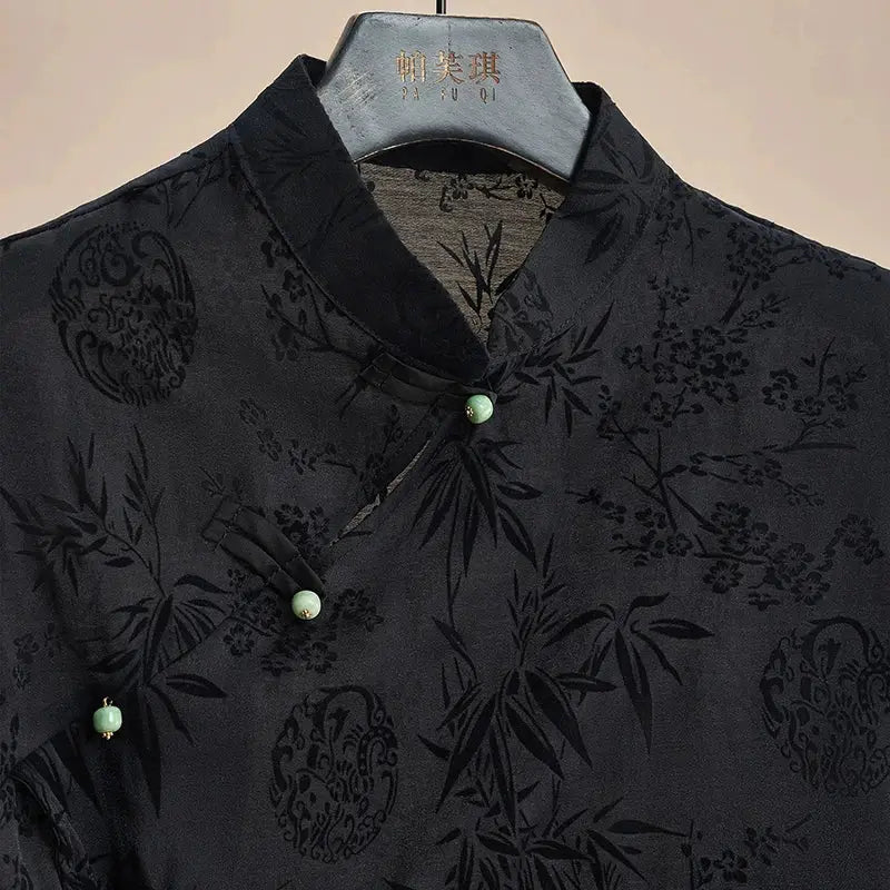 Cheongsam top black jacquard short-sleeve with Mandarin collar and jade-green buttons.