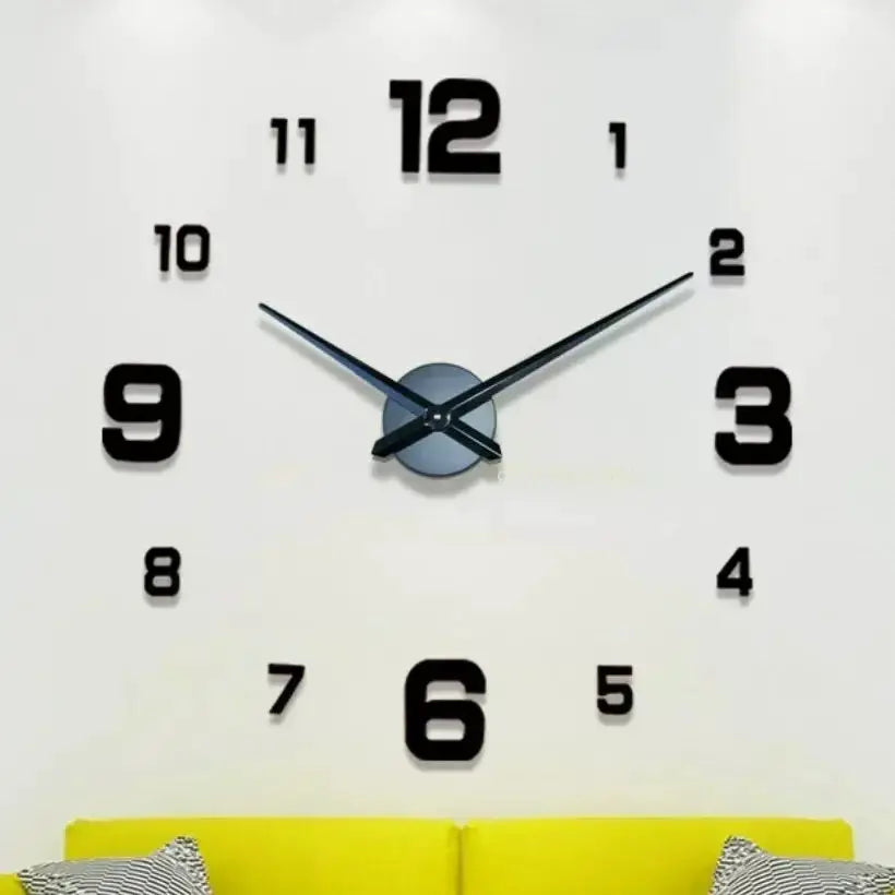 Analog wall clock with oversized black numerals on a white wall, blue center disc and metal hands above a yellow sofa.