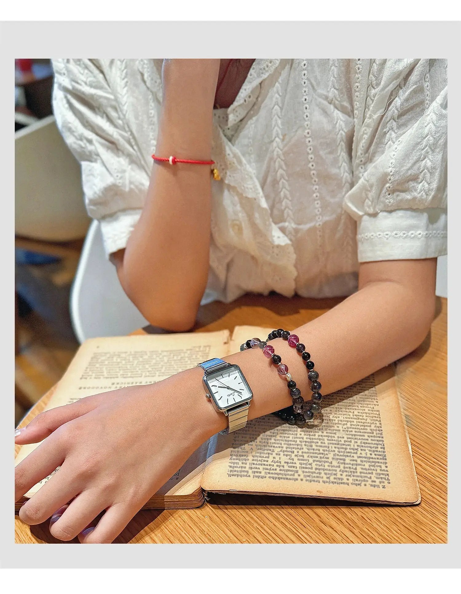 Womens square-dial quartz watch with silver stainless-steel strap, shown with 2 beaded bracelets
