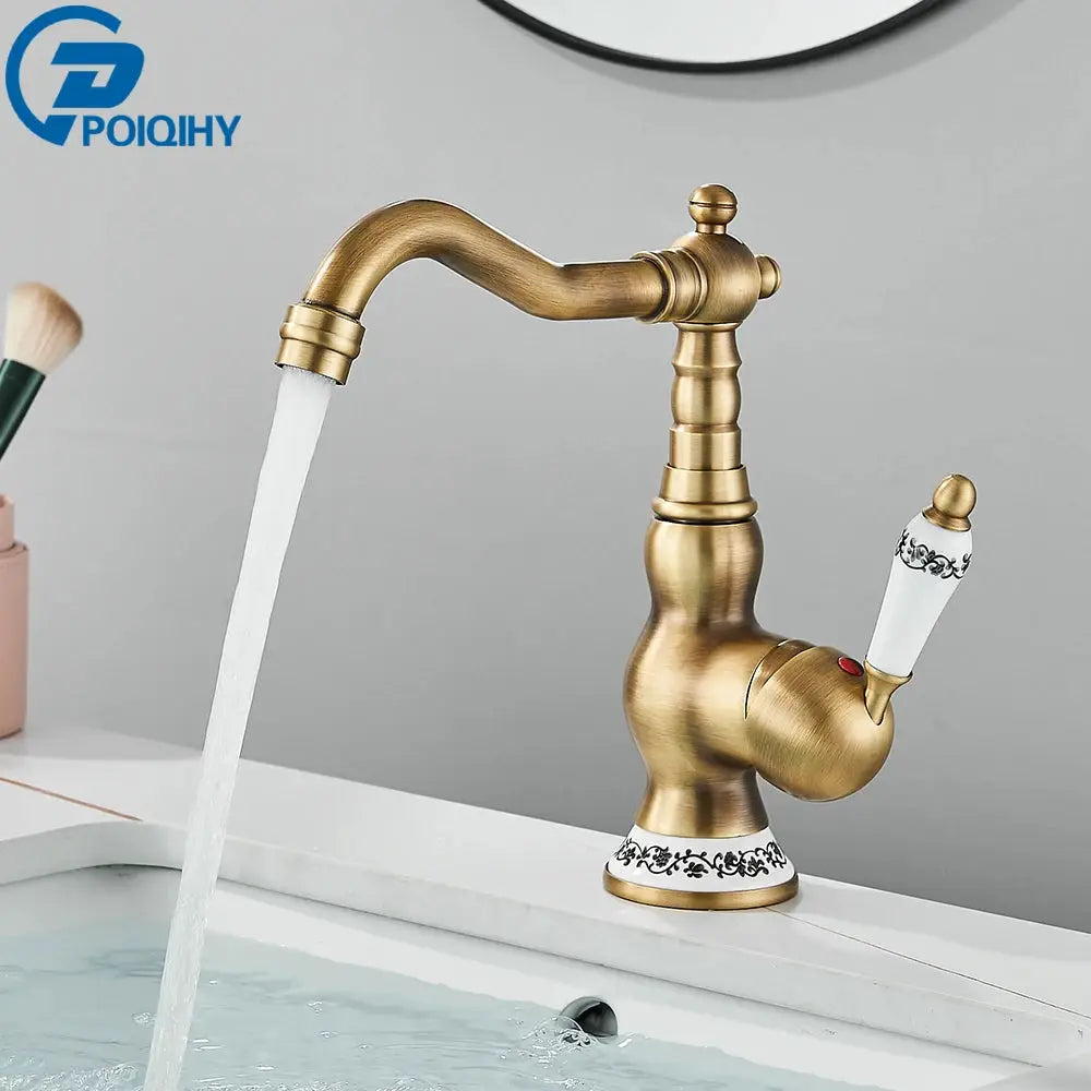Antique brass bathroom faucet with rotating spout and white ceramic handle.
