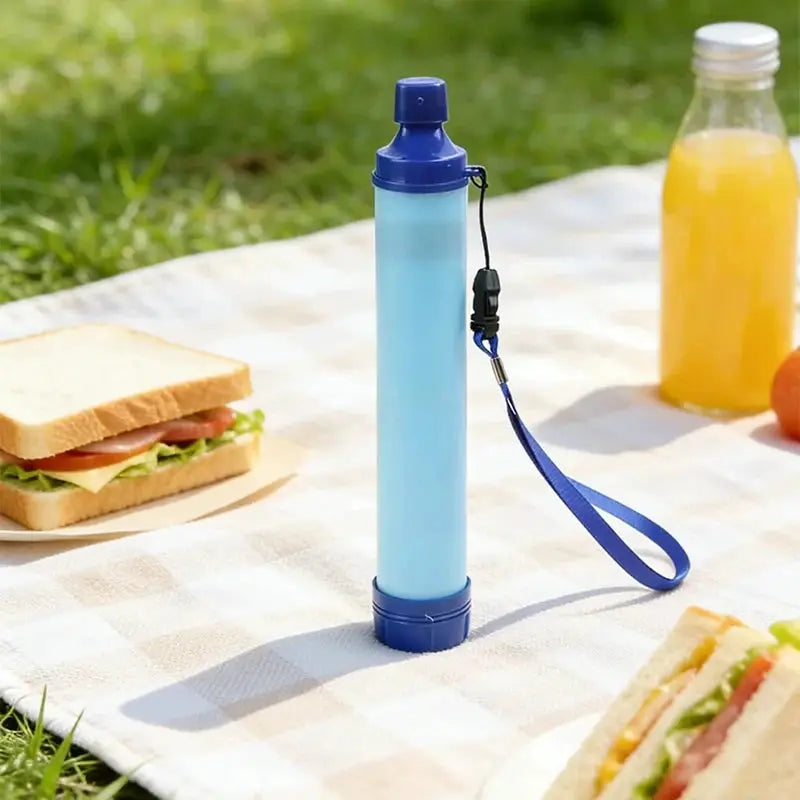 Portable emergency survival water filter straw by Simples Market, light blue with dark blue caps and wrist strap