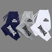 Lonsdale London jogger pants in navy, grey, and white with bold logo on leg