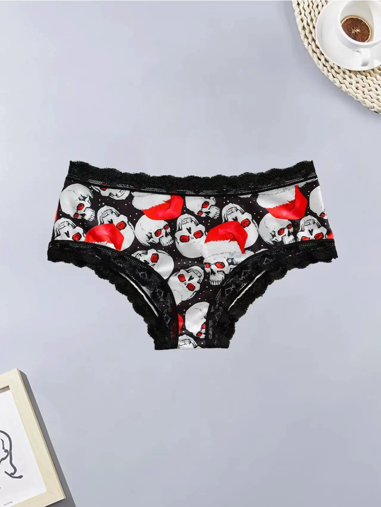 Women's lace panties with black skull print and red Santa hats, edged in black lace.