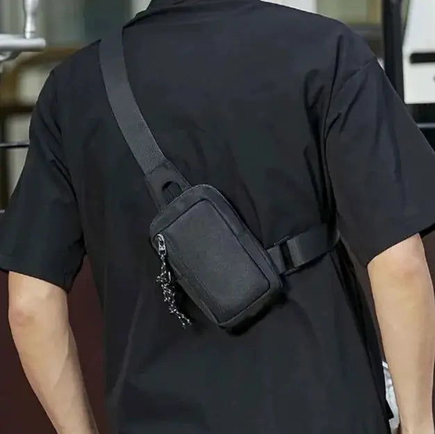 Men's black Oxford mini crossbody bag with a single strap worn across the chest.