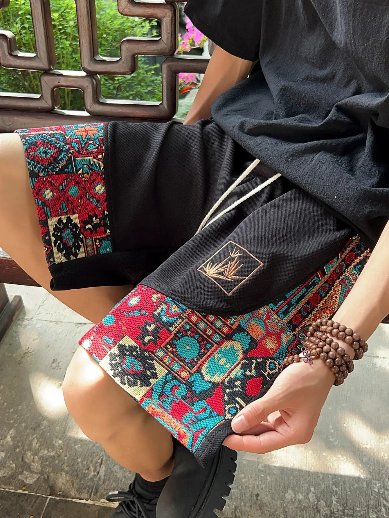 Men's ethnic embroidery shorts with pockets by Simples Market; black fabric with colorful geometric trim and drawstring