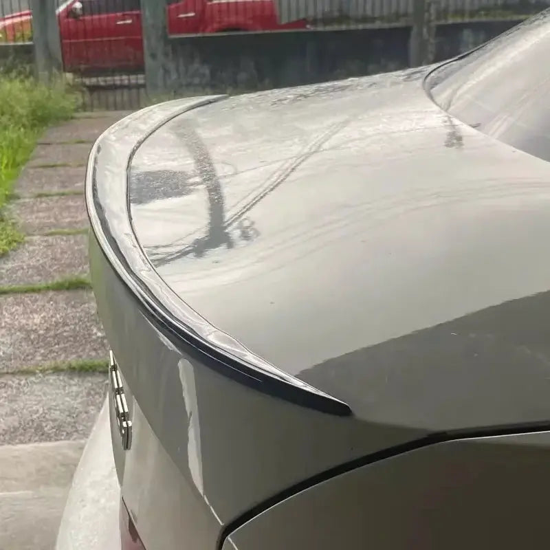 BMW 3 Series E90 sedan rear trunk spoiler lip on gray car.