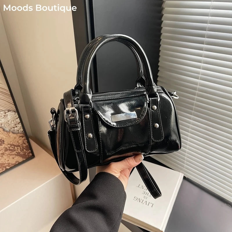 Mini top-handle handbag in black patent PU leather with dual handles and detachable crossbody strap.
