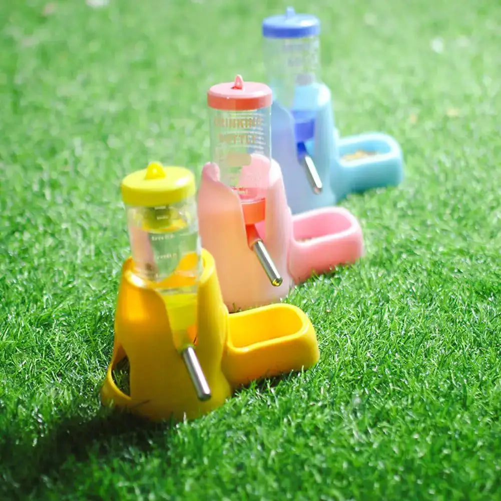 Small-pet water dispensers set: five colorful plastic units with bowls on grass
