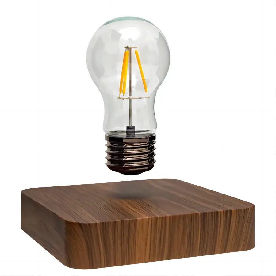 Magnetic levitation lamp with a floating glass LED bulb above a brown wooden base by Simples Market