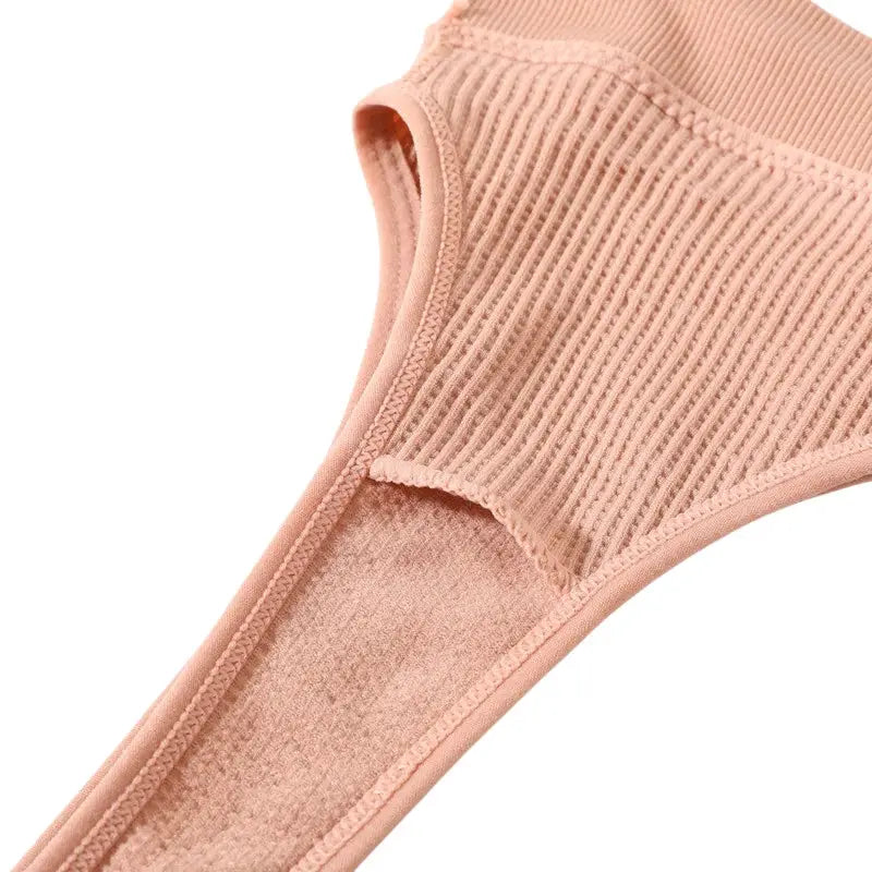 Women seamless ribbed bralette in peach pink fabric close-up; non-wire, soft knit