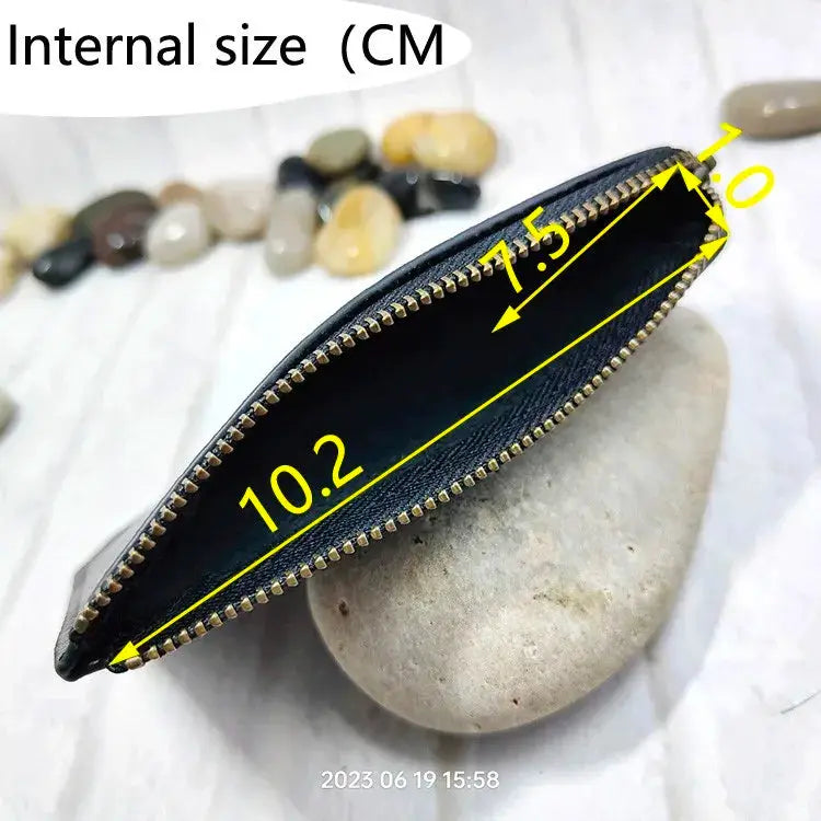 Mini zipper waist bag in black leather; slim belt pack for cards and phone with gold zipper.