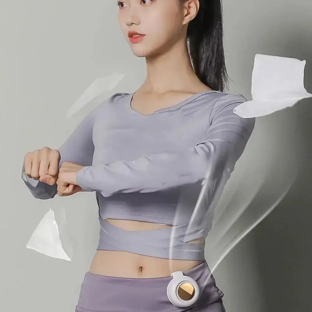 Portable clip-on bladeless waist fan attached to athletic wear; white circular unit.