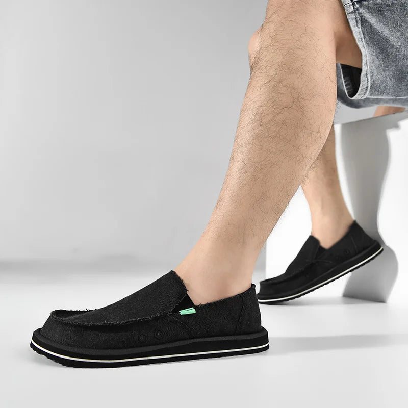 Pair of black canvas casual loafers for men, slip-on low-top with green accent and white-trim sole