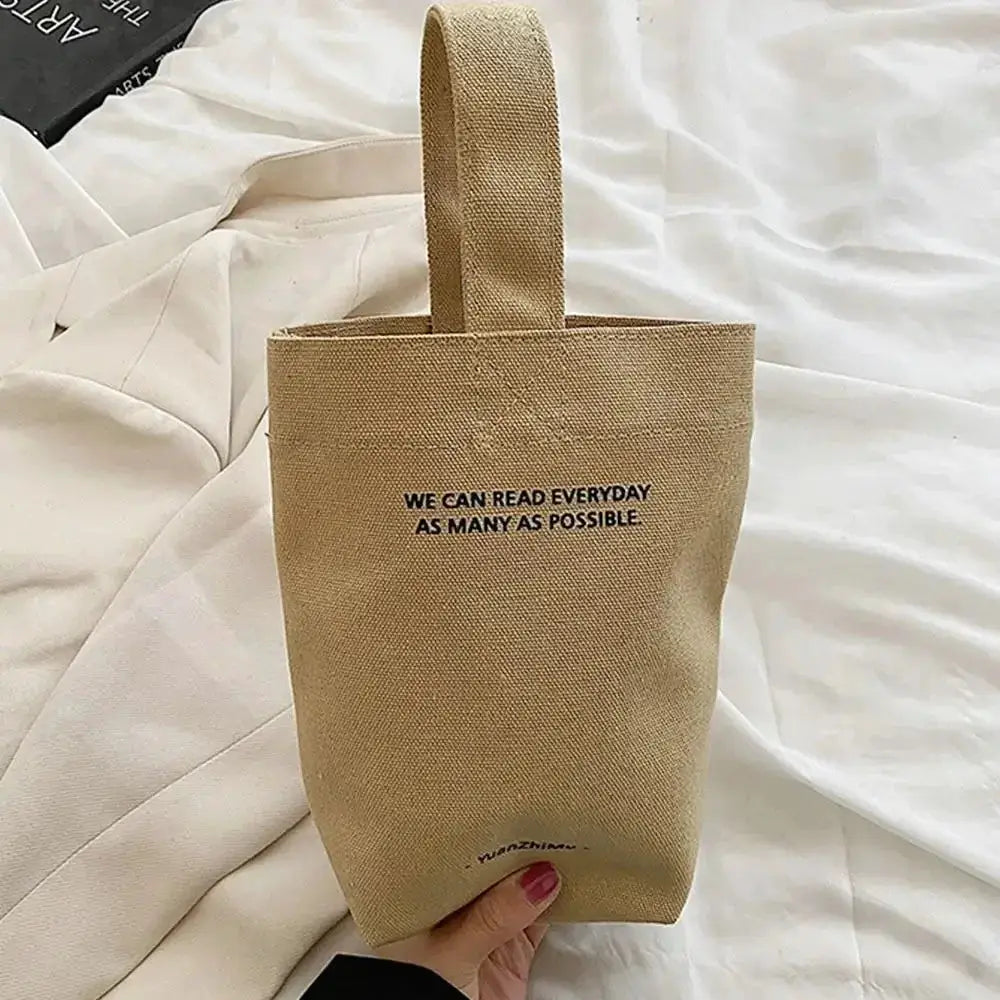 Casual canvas tote bag with short strap, beige fabric and front printed slogan.
