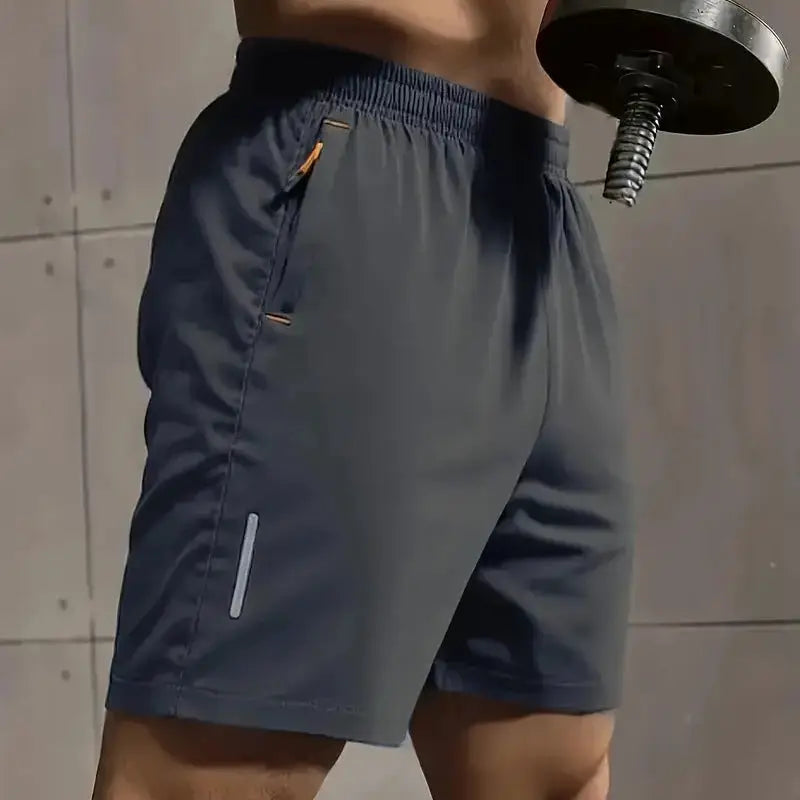 Men's sports shorts by Simples Market, dark gray breathable fabric with elastic waist and orange-trim side zip pocket.