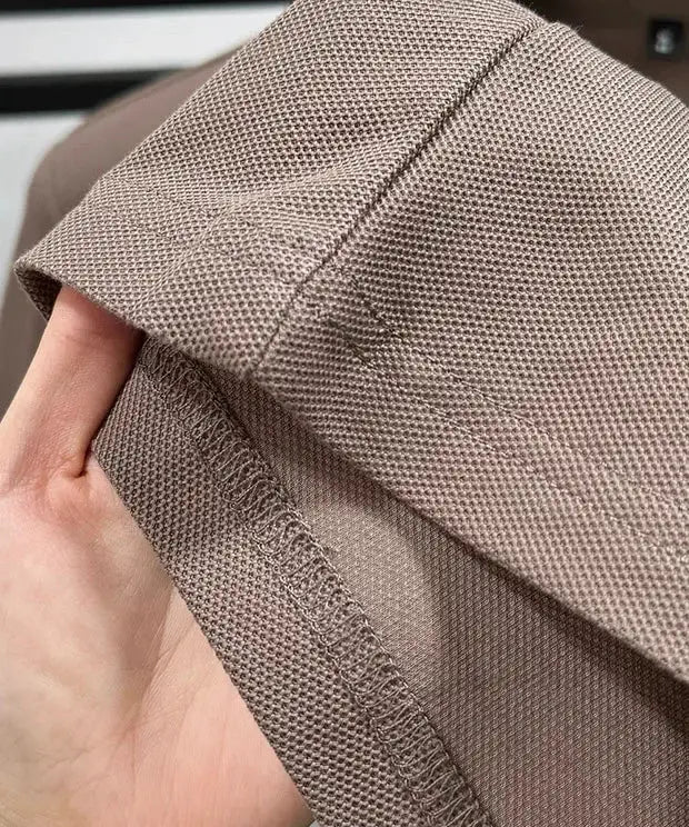Men's polo shirt close-up in taupe 100% cotton fabric with visible stitching.