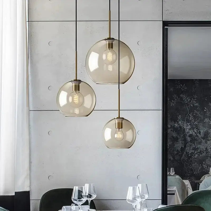 Nordic LED glass chandelier with three amber glass pendant lights and brass accents for dining room or living area.