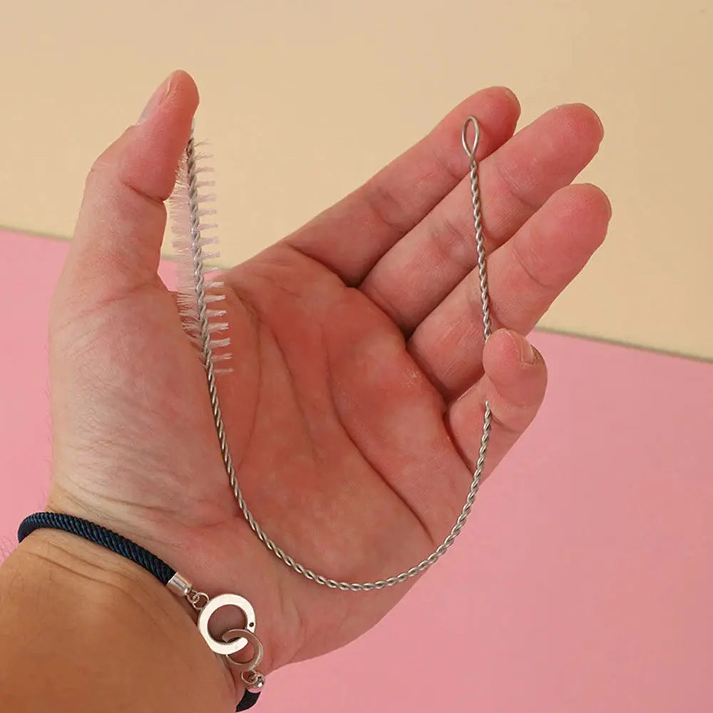 2 stainless steel cleaning brushes: straw brush with bristles and a twisted-wire pipe brush with a loop, held in a hand
