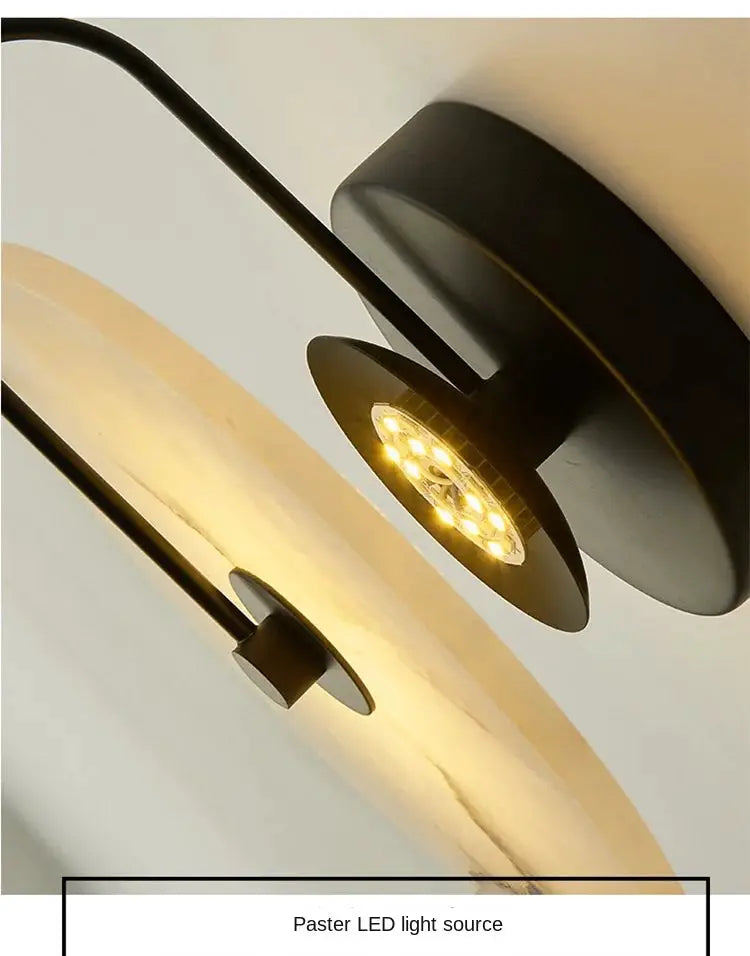 Nordic moon LED wall sconce with beige marble disk and black metal mount