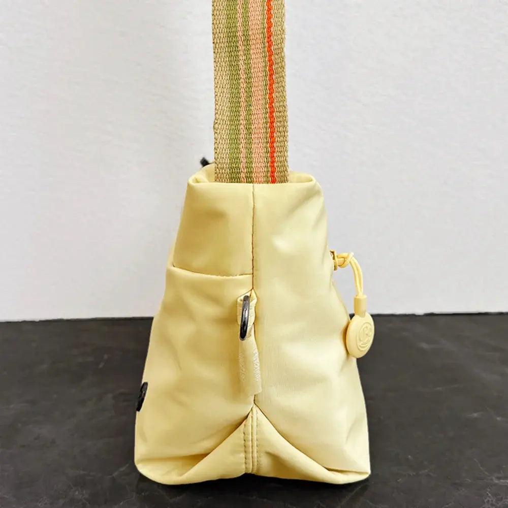 Ultra-light nylon crossbody bag for women in pale yellow with adjustable striped wide strap and zipper closure