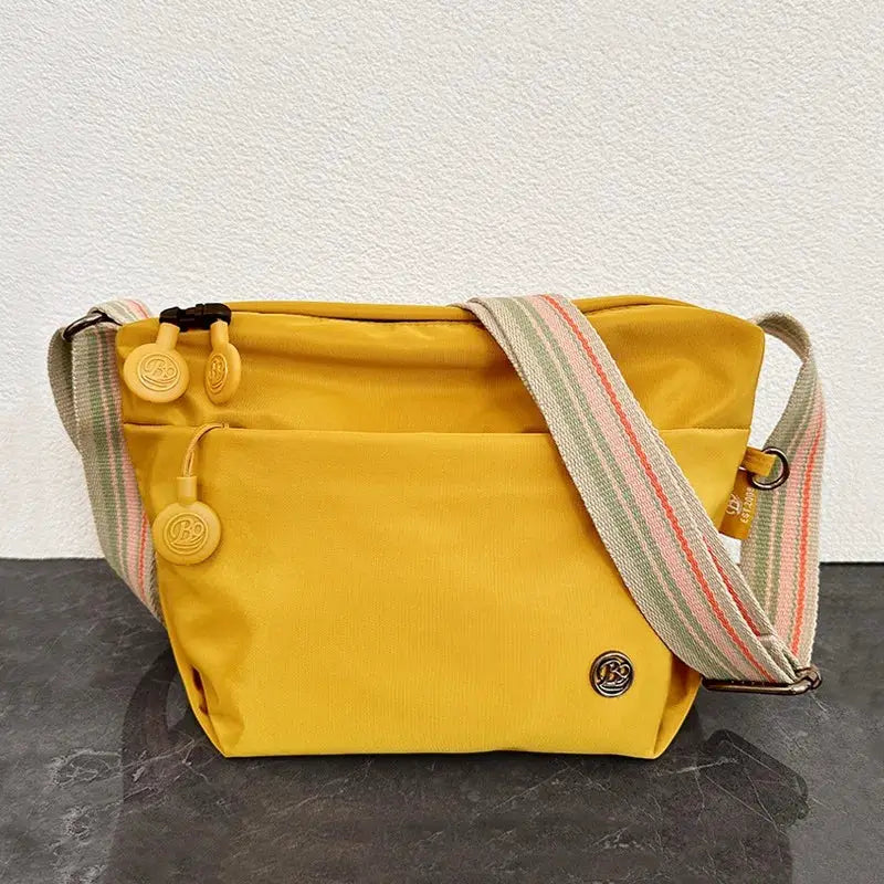 Nylon crossbody bag from Simples Market, yellow with adjustable striped strap and zipper closure