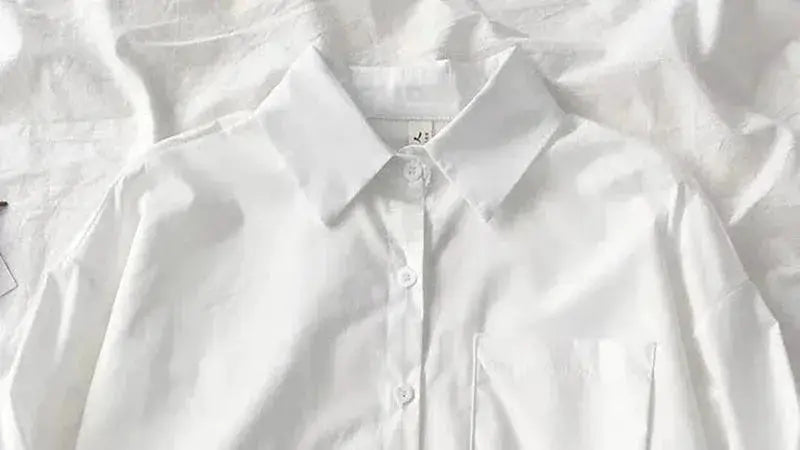 Women's oversized white button-down shirt with chest pocket and turn-down collar.
