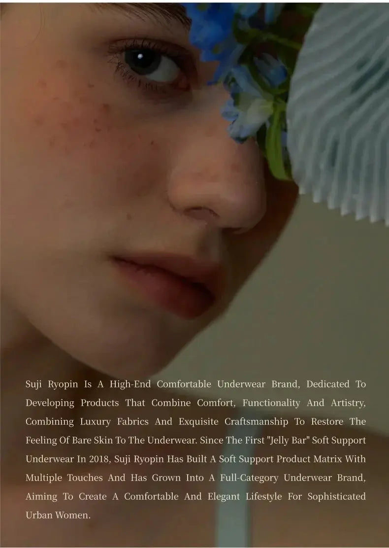 Close-up portrait of a woman with blue flowers near her eye and Suji Ryopin brand text overlay.