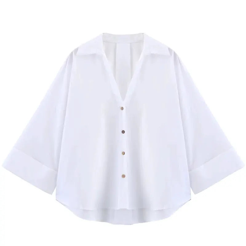 Women's oversized white button-front blouse with long sleeves and curved hem