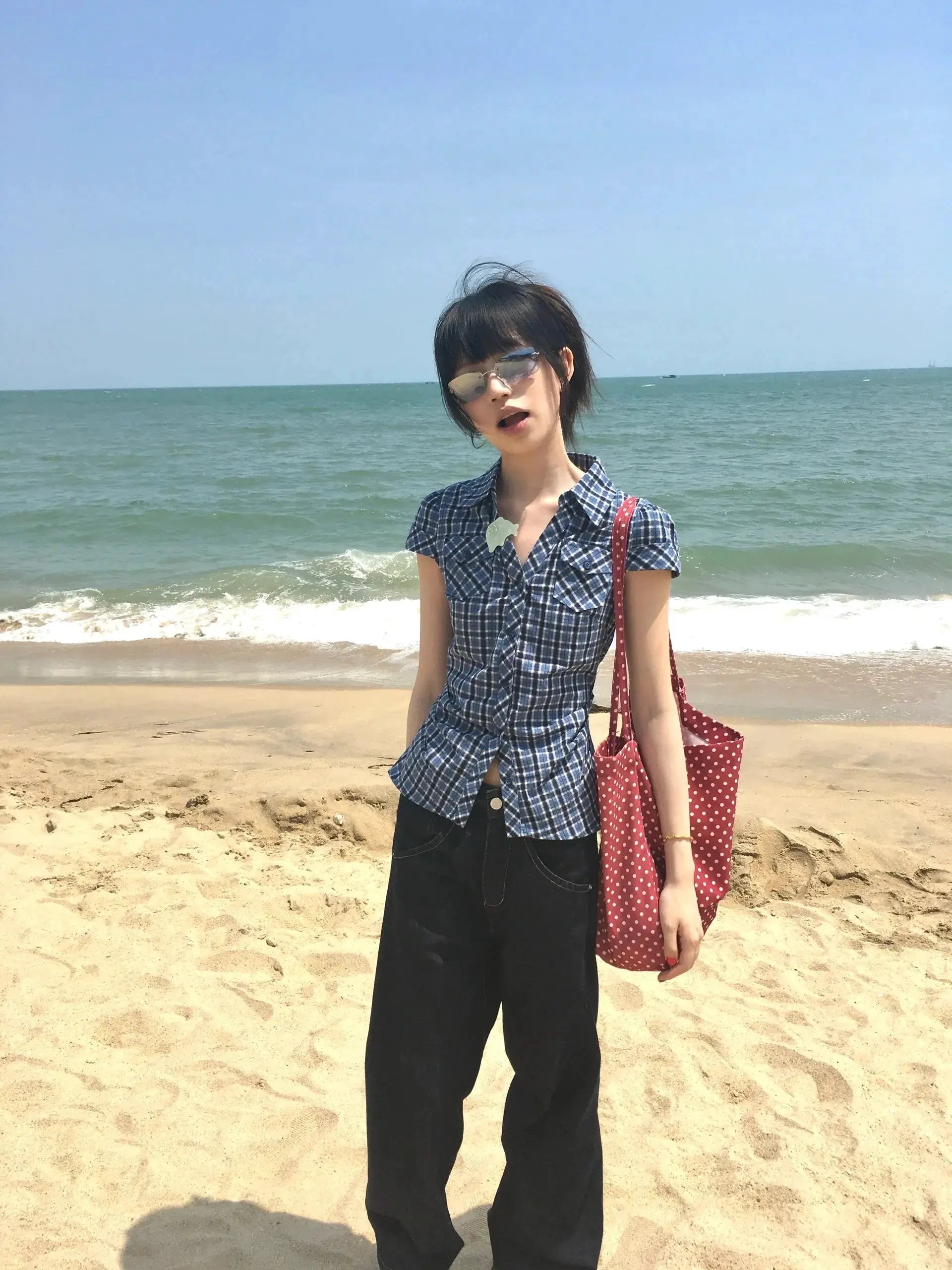 Karrram blue plaid short-sleeve V-neck shirt worn by model at the beach