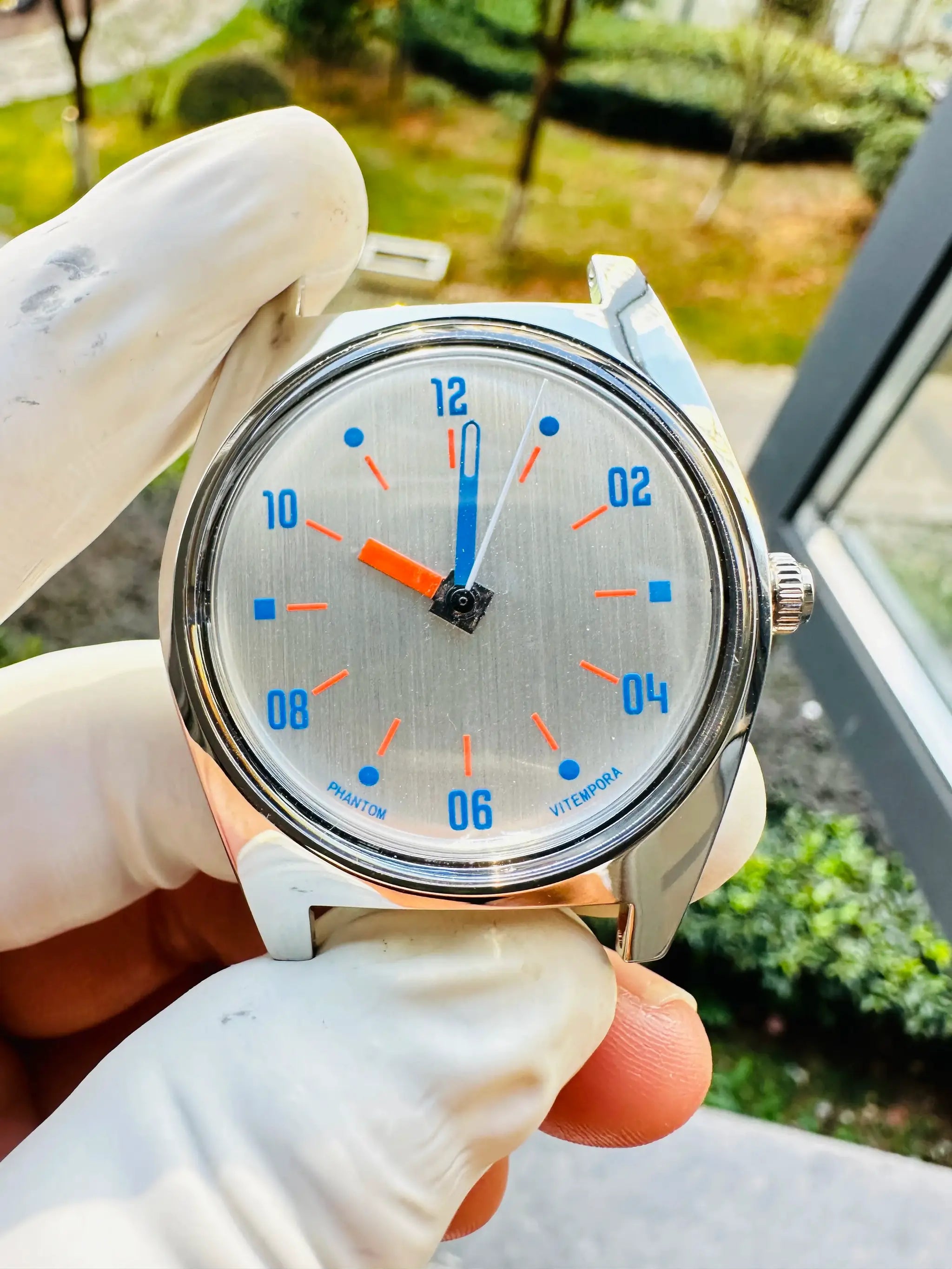 Simples Market 7120 hand-wind mechanical watch, 36mm, silver dial with blue numerals and orange markers.