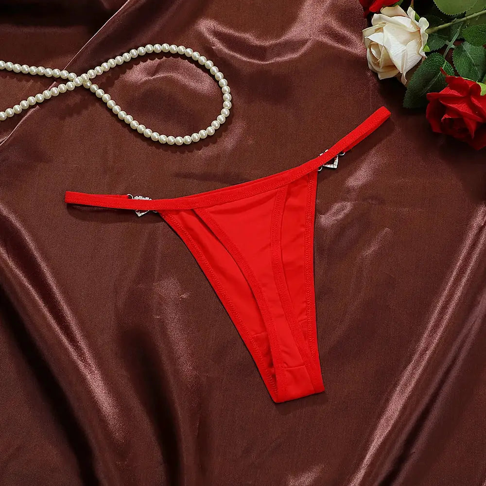 Simples Market red low-rise thong underwear on satin backdrop with pearl necklace and roses