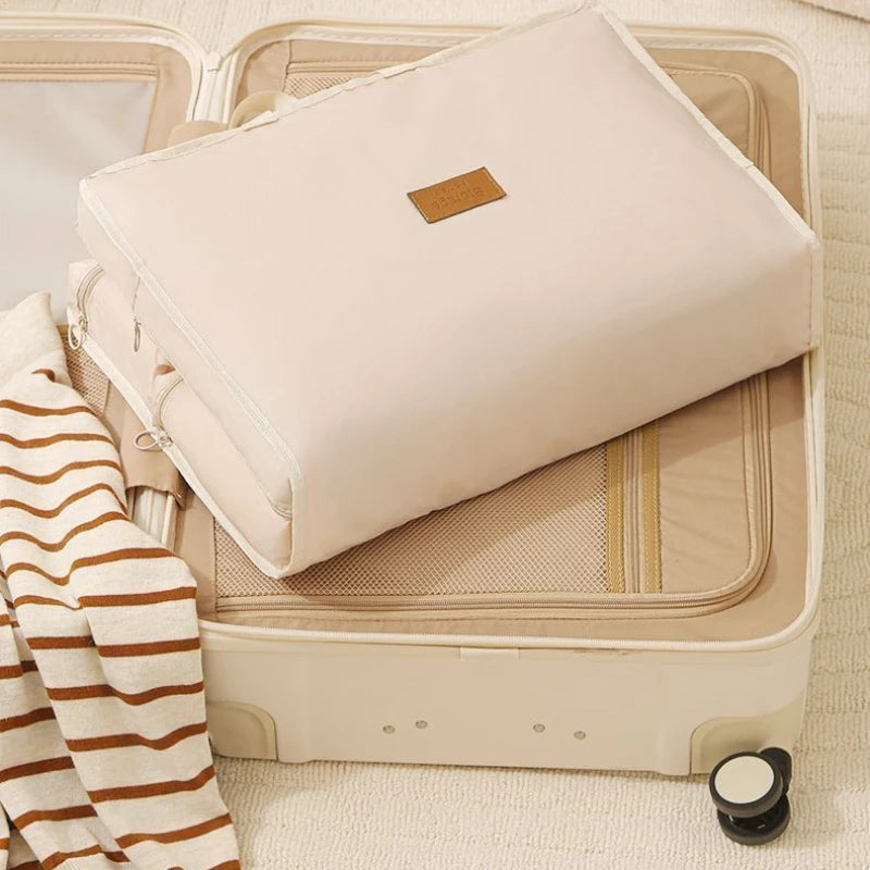 Simples Market business travel hanging bag, cream fabric, foldable garment organizer on an open suitcase