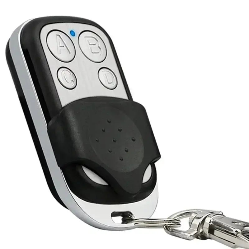 Universal garage door opener remote by Simples Market, black and silver four-button with key ring, 433MHz