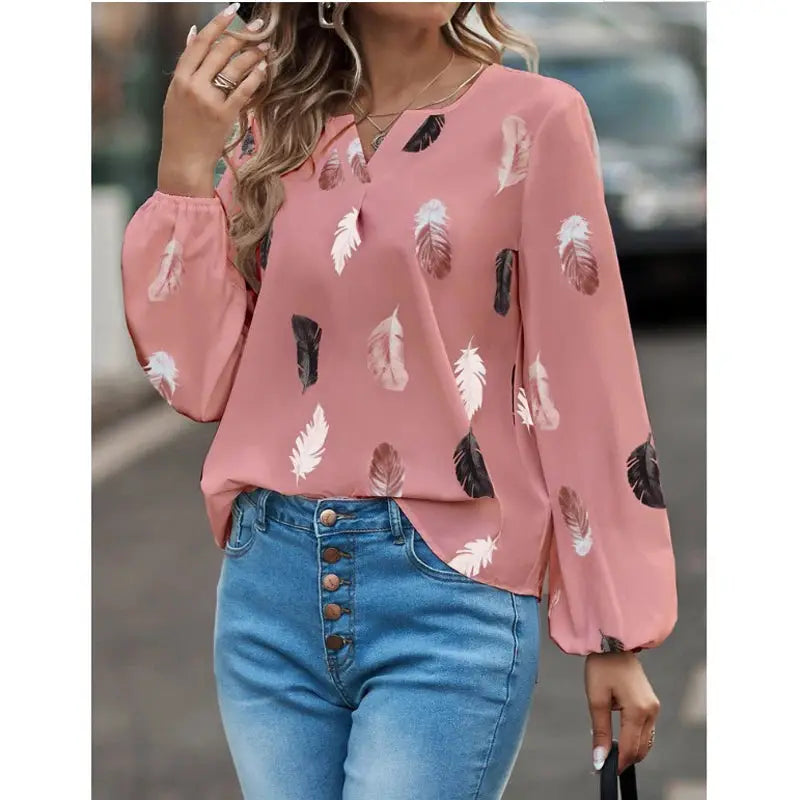 Women's pink feather-print chiffon blouse with long sleeves, from Simples Market worn with blue jeans.