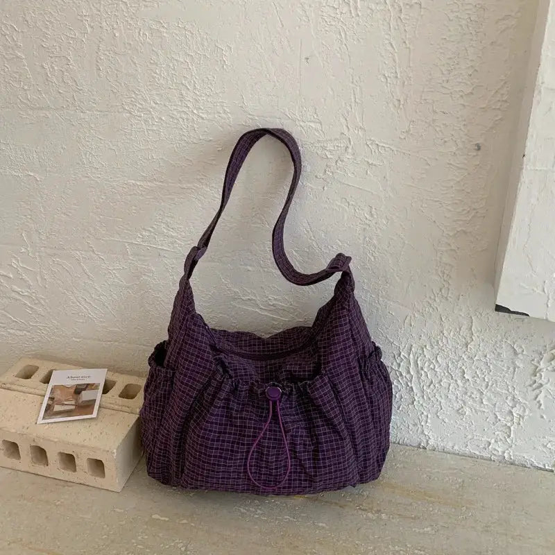 Purple plaid nylon shoulder bag with drawstring closure and zipper tote for commuters.