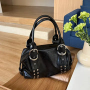 Black PU leather shoulder bag with riveted straps, silver rings and studs, double top handles.
