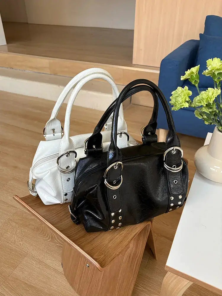 Two rivet-style women's shoulder bags in black and white PU leather with silver-tone hardware.