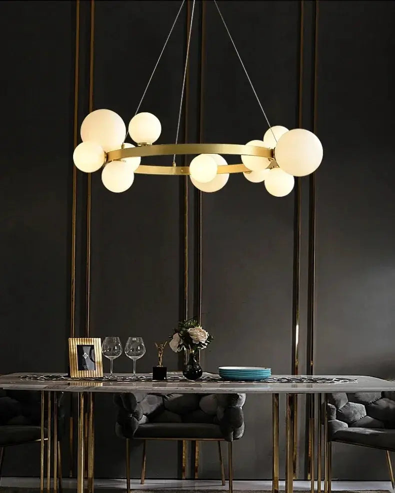 Simple chandelier by Simples Market; gold ring with frosted globe bulbs, modern hanging lamp for dining or living room.