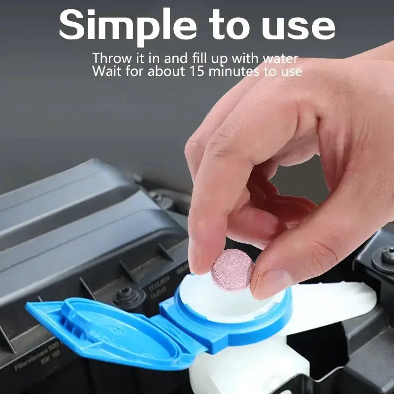 Car windshield cleaner tablets being dropped into blue cap; hand holds pink effervescent tablet for auto glass cleaning.
