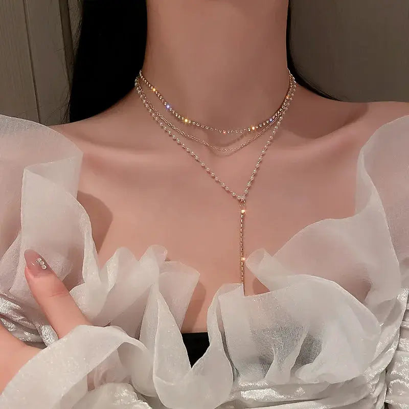 Layered pearl choker necklace with gold-tone beads and a drop pendant.