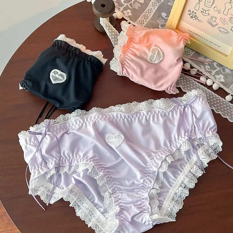 Simples Market lingerie: set of 3 satin lace-trim panties in lavender, pink, and black with heart embroidery